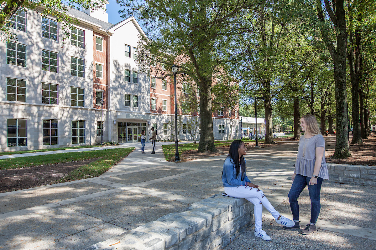 Two female students chatting outside of Lewis Hall
