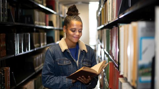 Female student browsing books in William T. Young Library