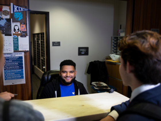 Resident Advisor assists students at residence hall front desk