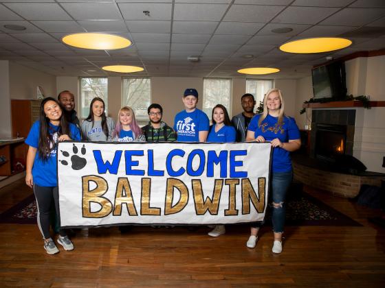 First-generation students holding "Welcome Baldwin" sign