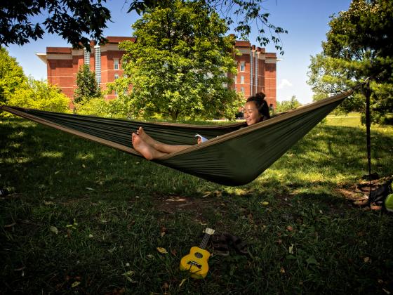 Student in hammock outside William T. Young Library during the summer
