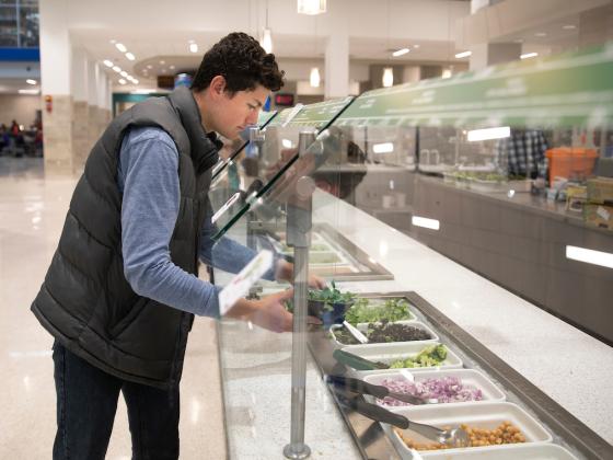 Student getting food from buffet line in Champions Kitchen